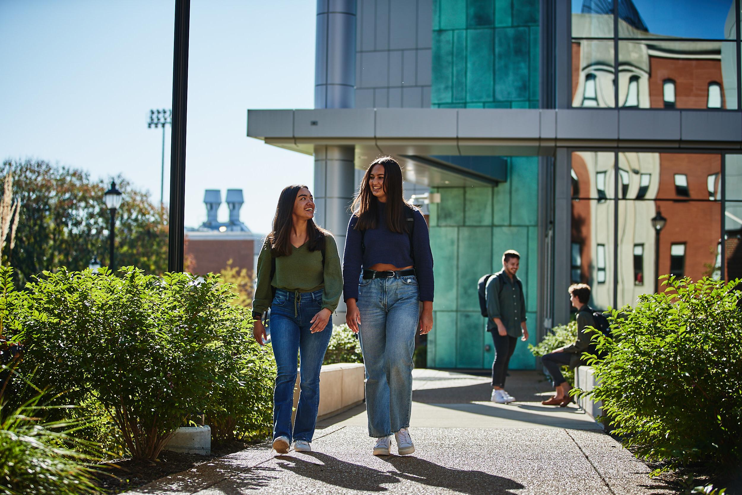 Two students walking outside the entrance of the engineering buildong